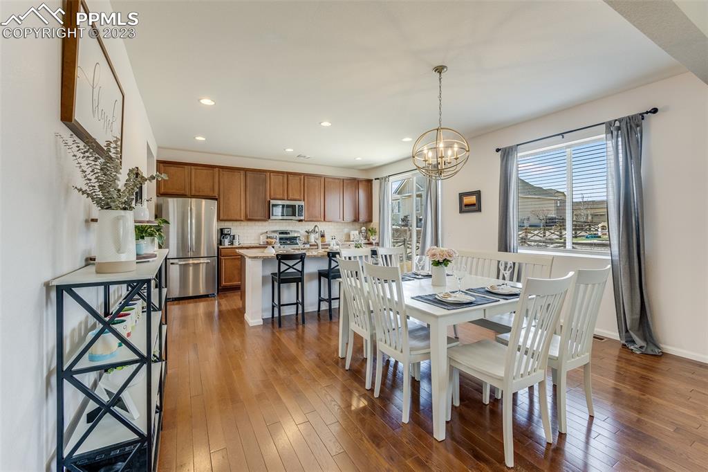 7122 Golden Acacia Lane Colorado Springs, CO 80927 - Photo 8 of 37 a view of a dining room with furniture window and wooden floor