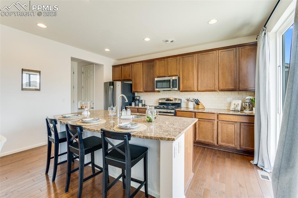 7122 Golden Acacia Lane Colorado Springs, CO 80927 - Photo 9 of 37 a kitchen with a dining table chairs and refrigerator