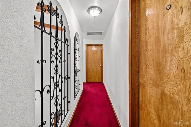 a view of a hallway with wooden floor and stairs