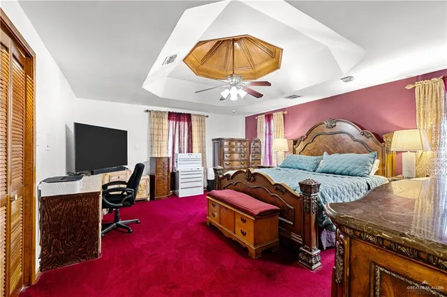 a bedroom with a bed and a flat tv screen on the dresser