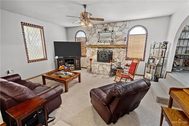 a living room with furniture a fireplace and a flat screen tv