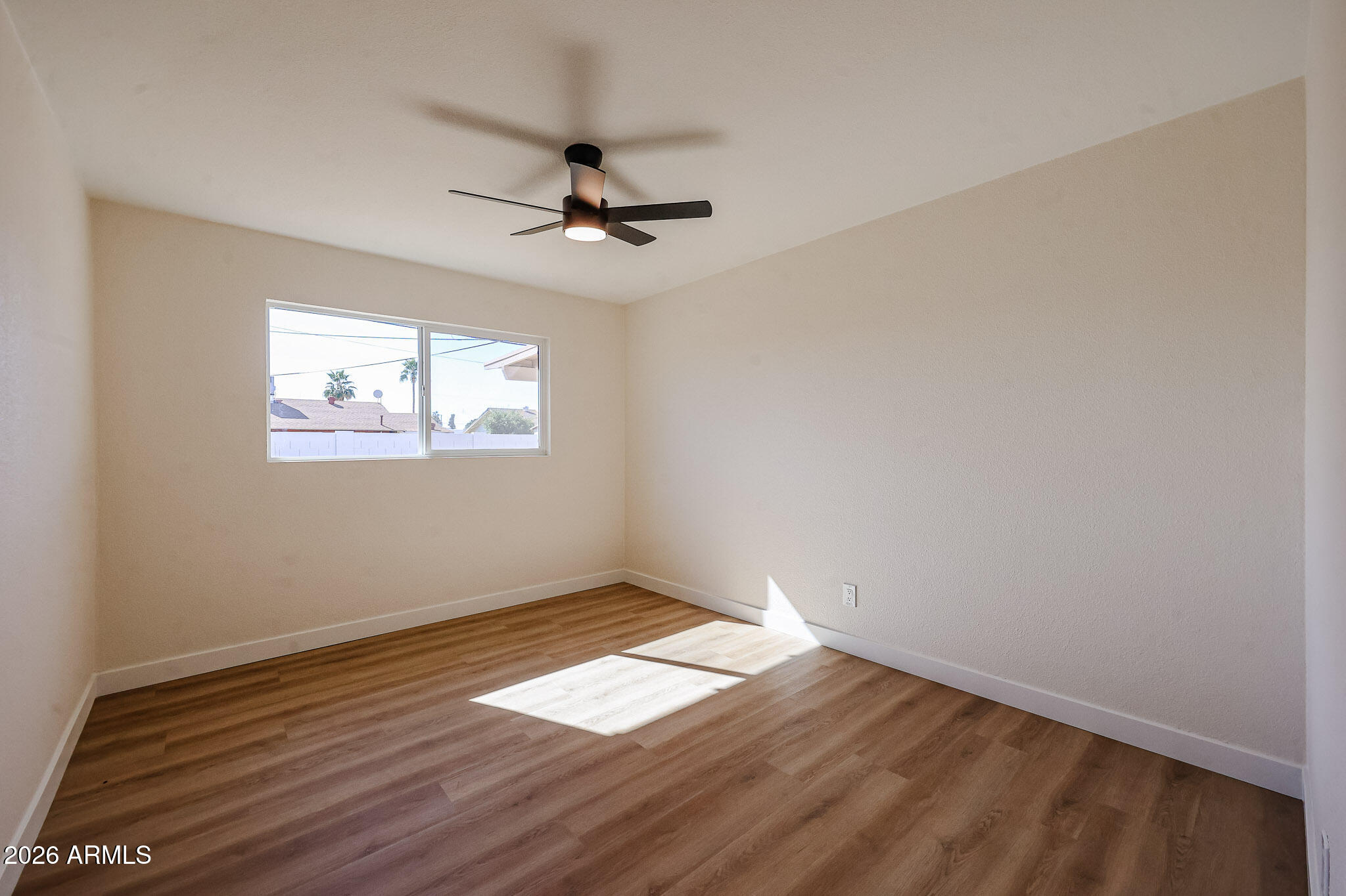 3337 West Ocotillo Road Phoenix, AZ 85017 - Photo 14 of 30 a view of empty room with wooden floor and fan