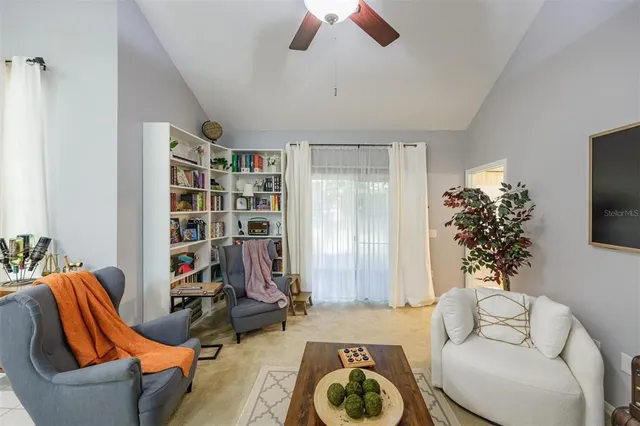 a living room with furniture a chandelier and a potted plant