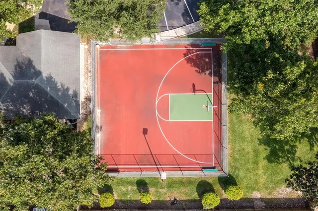 an aerial view of residential houses with outdoor space and trees