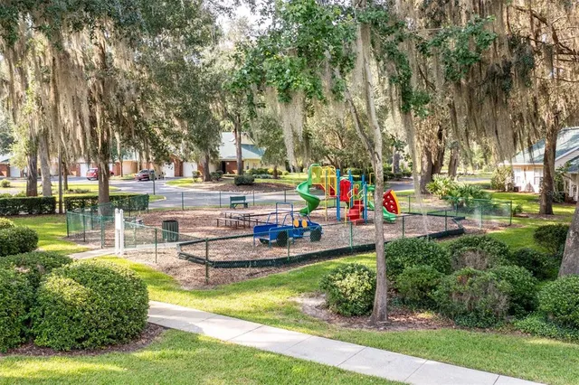 an aerial view of residential houses with outdoor space and trees