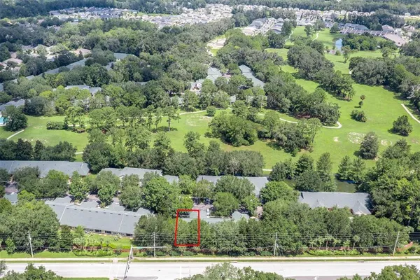 an aerial view of residential house with outdoor space and trees all around