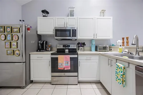 a kitchen with stainless steel appliances granite countertop a refrigerator stove and white cabinets