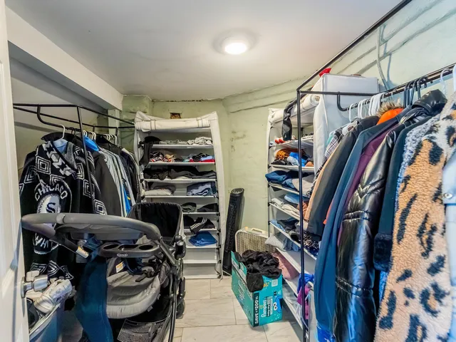 a view of walk in closet with clothes and shoes
