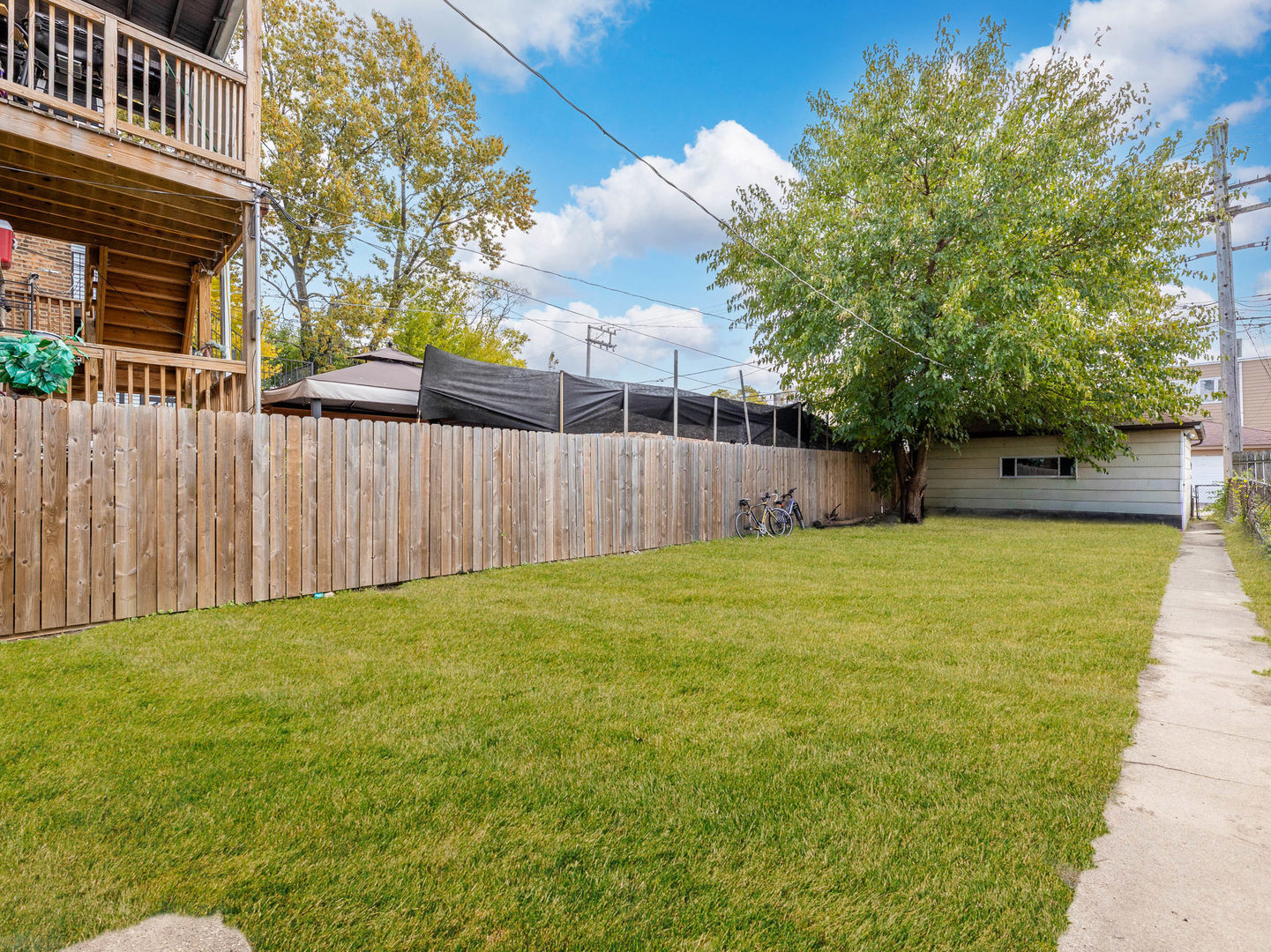 4747 West Monroe Street Chicago, IL 60644 - Photo 25 of 31 a view of a backyard with a tree and wooden fence
