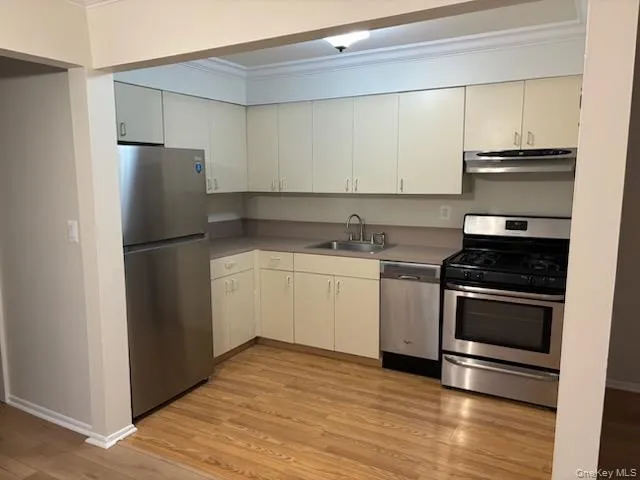 a kitchen with a sink stainless steel appliances and cabinets
