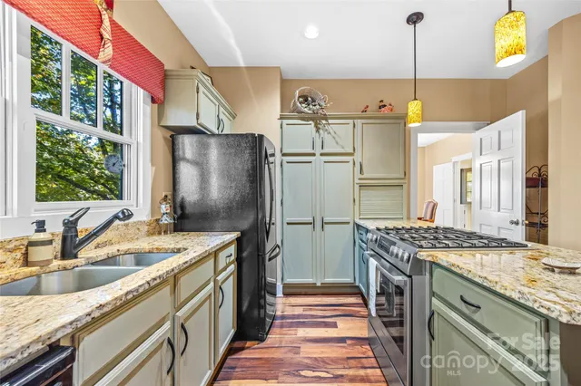 a open kitchen with stainless steel appliances granite countertop a stove and refrigerator