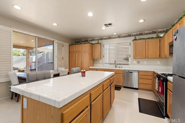 a kitchen with stainless steel appliances kitchen island granite countertop a sink and cabinets