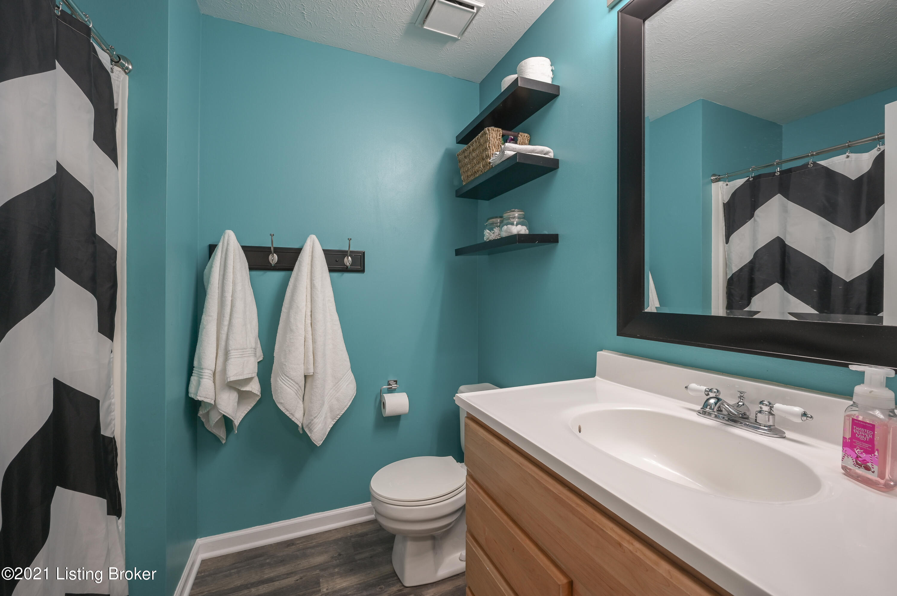 1222 Cedarbrook Road Goshen, KY 40026 - Photo 30 of 46 This bathroom features a shower/tub combo, a single vanity, floating shelves, a large mirror, and sconce lighting