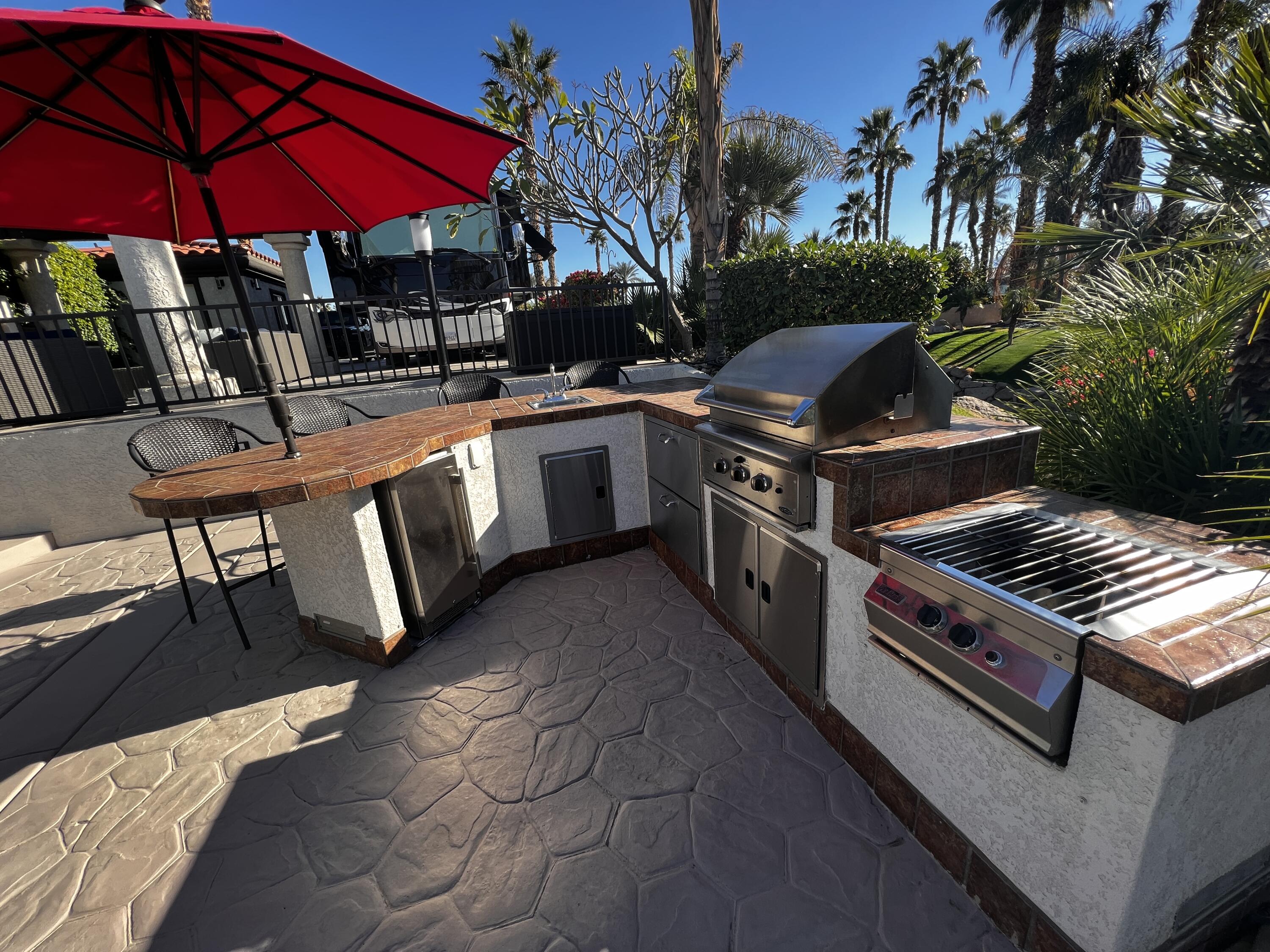 80501 Ave 48, Unit 110 Indio, CA 92201 - Photo 14 of 35 a view of a chairs and table under an umbrella in patio