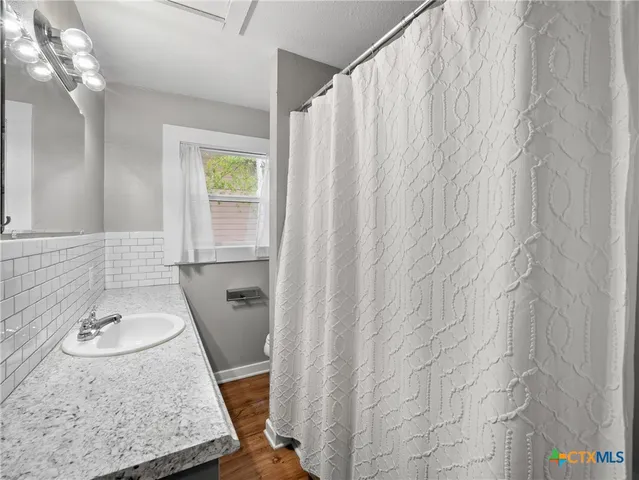 a bathroom with a granite countertop sink and a mirror