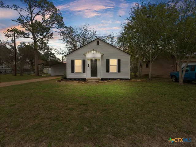 a front view of house with yard and green space