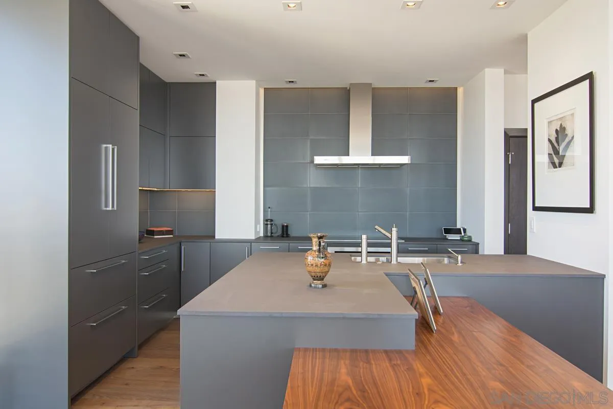 3634 7th Avenue, Unit 14H San Diego, CA 92103 - Photo 9 of 41 a kitchen with a wooden floor and cabinets