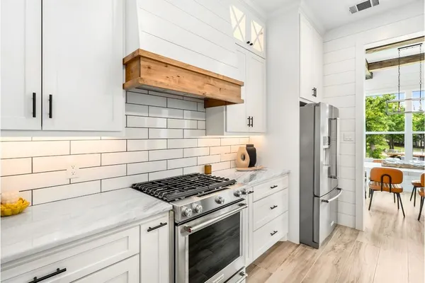 a kitchen with a table chairs stove and cabinets