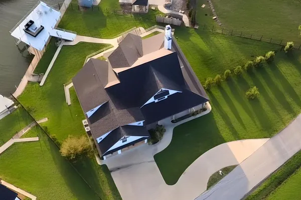 a aerial view of a house with swimming pool lawn chairs and a fire pit
