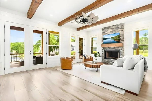 a living room with furniture large window and wooden floor