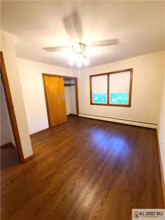 an empty room with wooden floor and window
