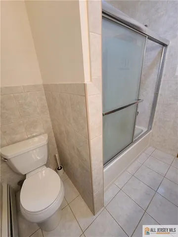 a white toilet sitting next to a shower