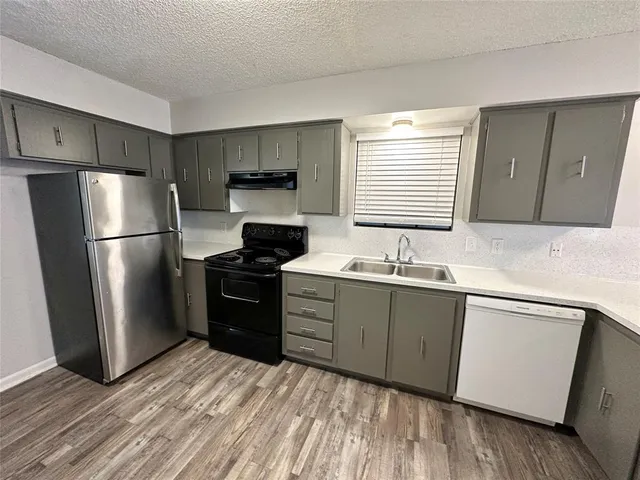 a kitchen with a refrigerator stove and sink