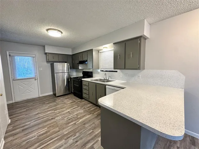 a kitchen with a sink a refrigerator and cabinets