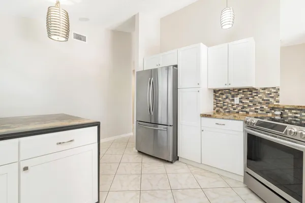 a kitchen with a stove top oven and refrigerator