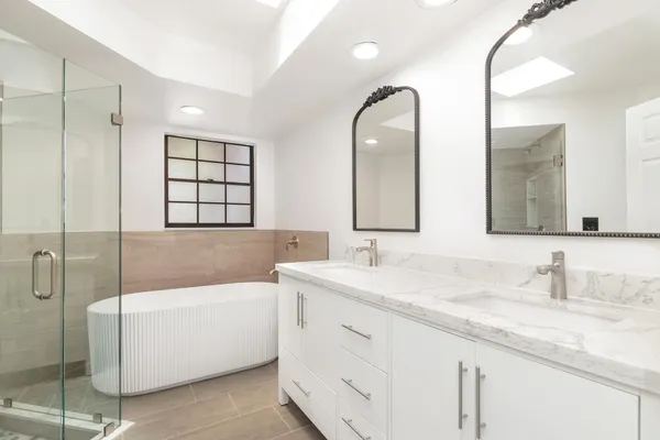 a bathroom with a granite countertop sink mirror and bathtub