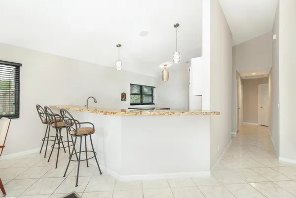 a view of kitchen with furniture and refrigerator