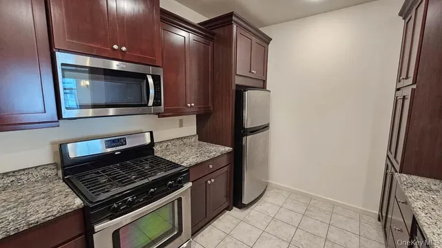 a kitchen with granite countertop a stove and a microwave