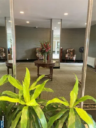a living room with furniture a mirror and a flat screen tv