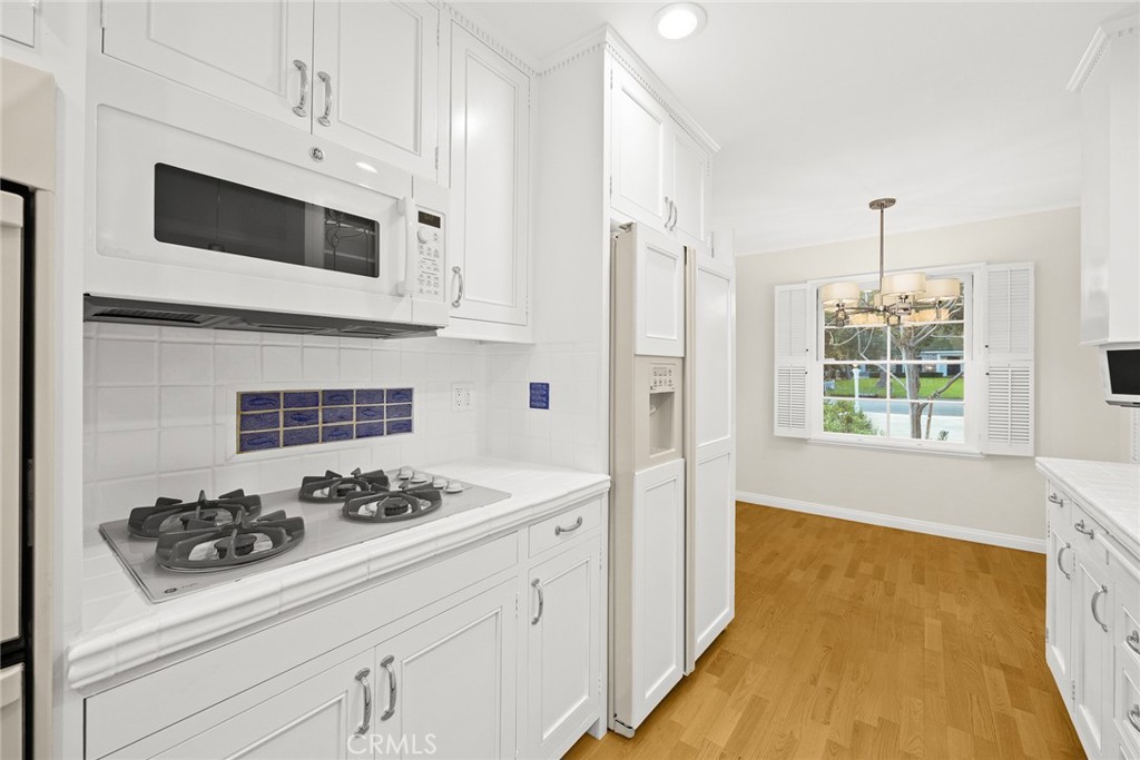 1300 Ramona Road Arcadia, CA 91006 - Photo 20 of 39 a kitchen with stainless steel appliances a white stove top oven a sink dishwasher and white cabinets with wooden floor