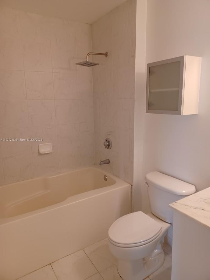 133 Northeast 2nd Avenue, Unit 412 Miami, FL 33132 - Photo 15 of 32 a white toilet and tub sitting next to a bathroom sink