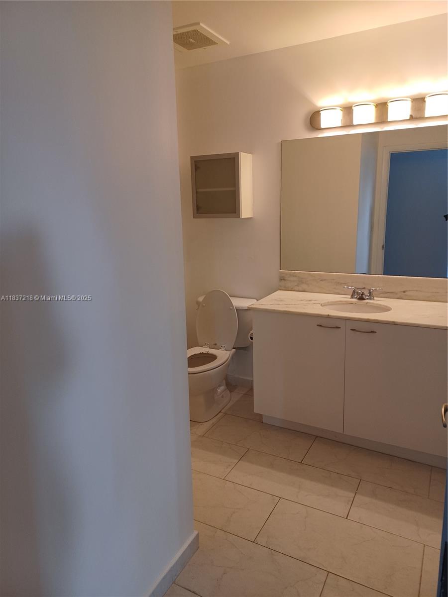 133 Northeast 2nd Avenue, Unit 412 Miami, FL 33132 - Photo 16 of 32 a bathroom with a sink a toilet and mirror