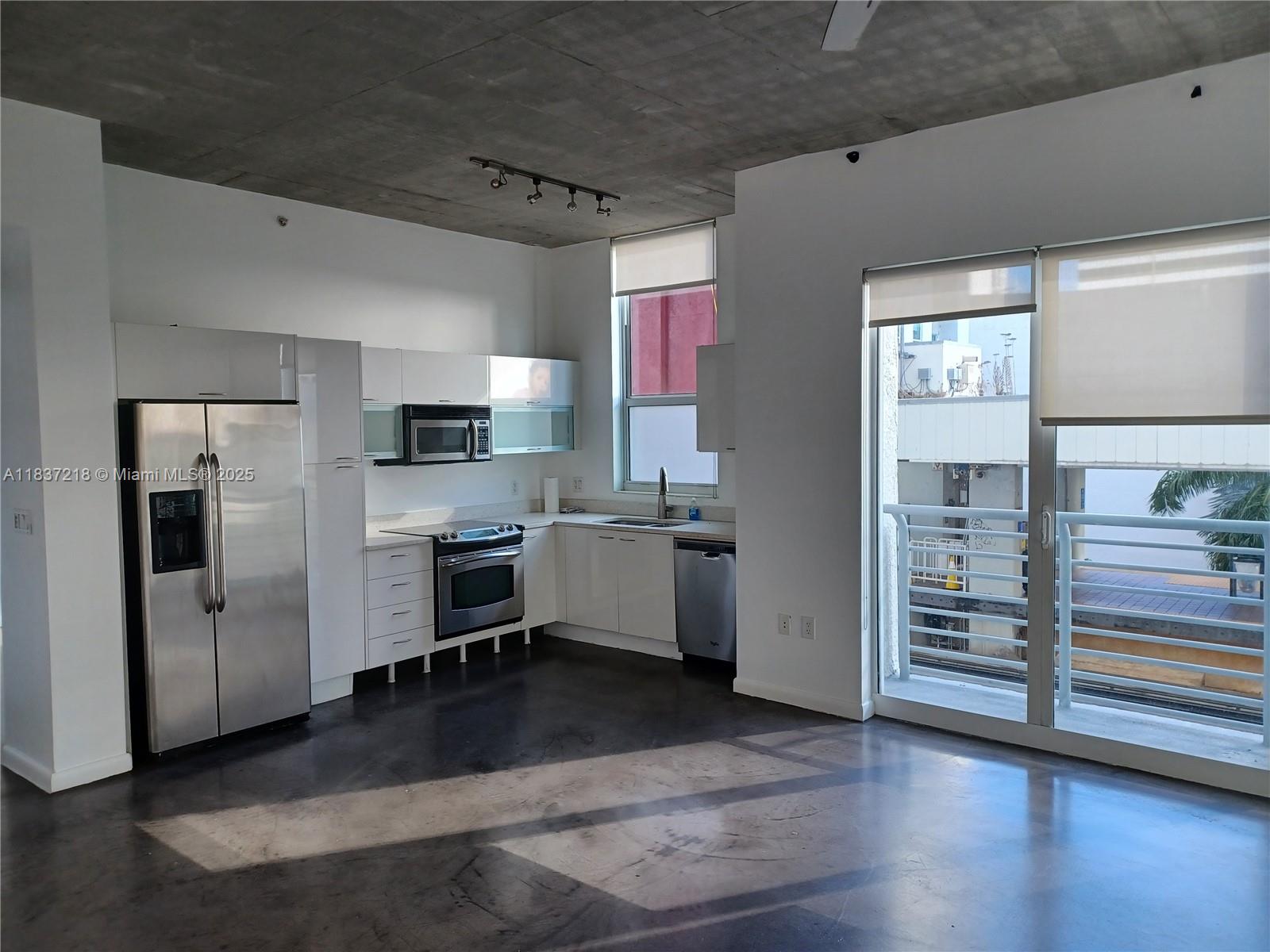 133 Northeast 2nd Avenue, Unit 412 Miami, FL 33132 - Photo 2 of 32 a kitchen with a refrigerator and a stove top oven