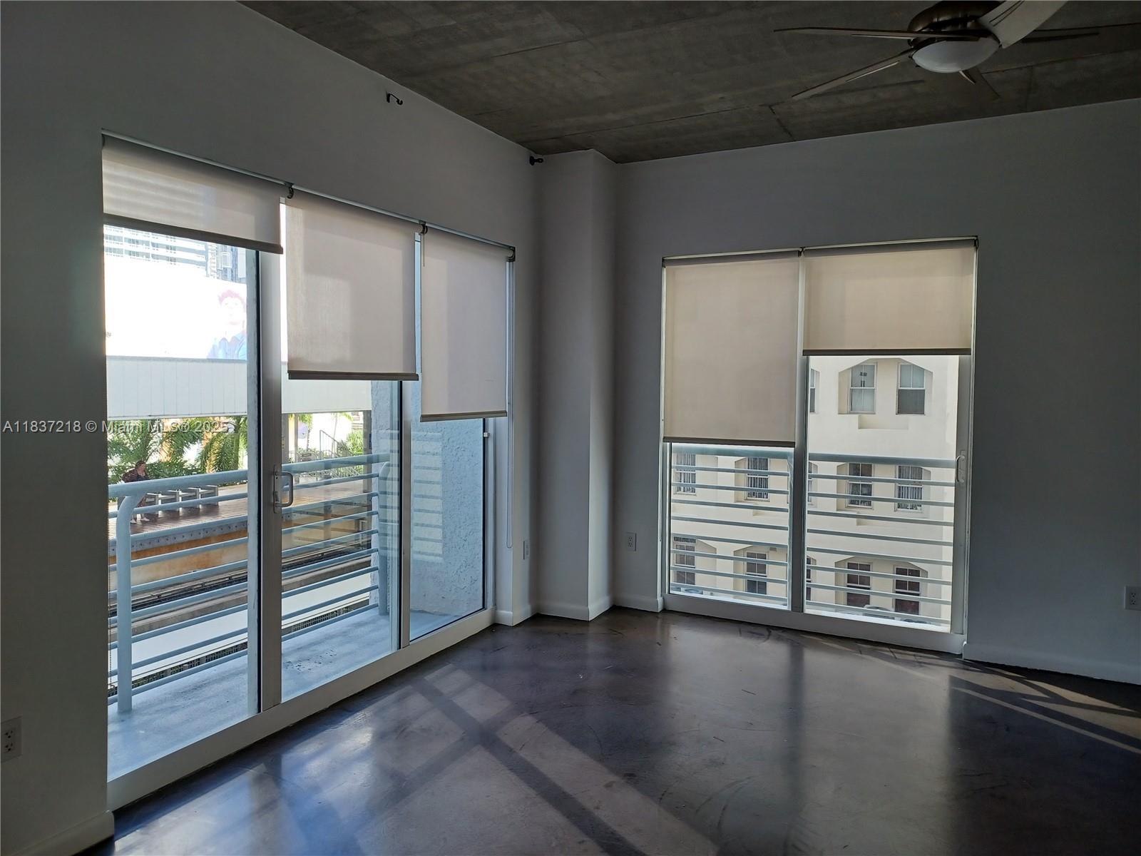 133 Northeast 2nd Avenue, Unit 412 Miami, FL 33132 - Photo 4 of 32 a view of an empty room with wooden floor and a window