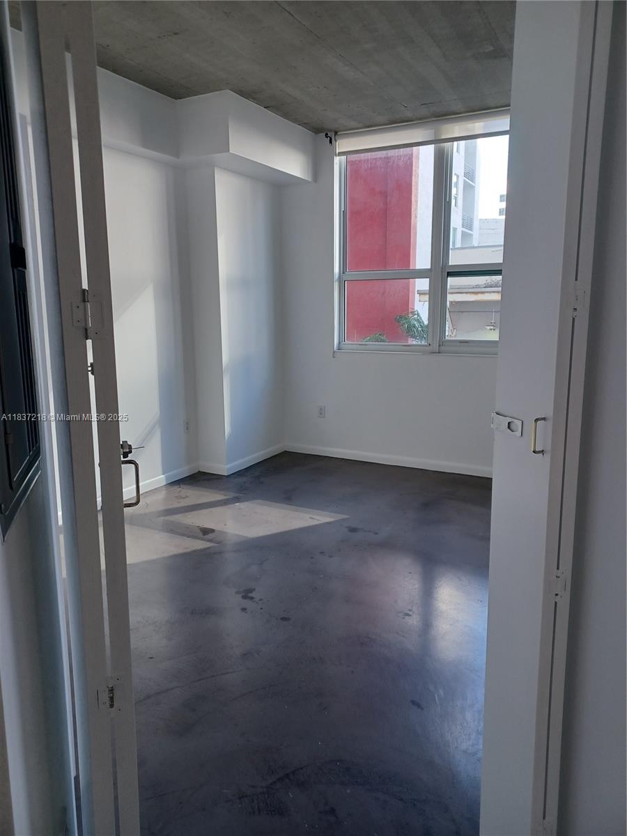 133 Northeast 2nd Avenue, Unit 412 Miami, FL 33132 - Photo 9 of 32 an empty room with windows
