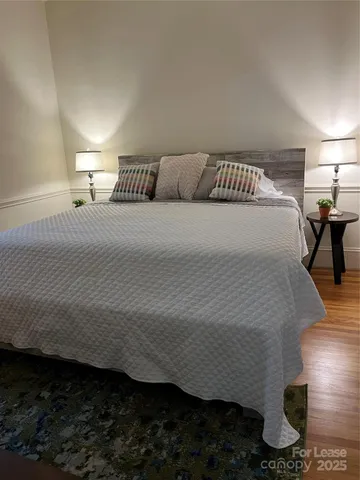 a bedroom with a bed and wooden floor