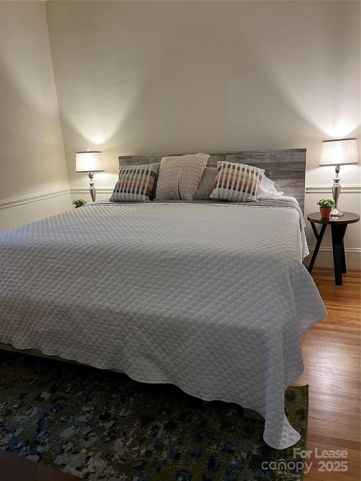2615 Sharon Road Charlotte, NC 28211 - Photo 17 of 21 a bedroom with a bed and wooden floor