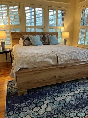 a large bed sitting in a bedroom next to a window