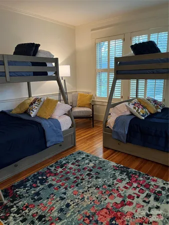 a bedroom with bed and wooden floor