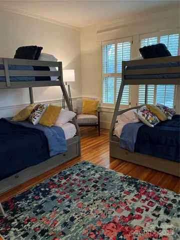 a bedroom with bed and wooden floor
