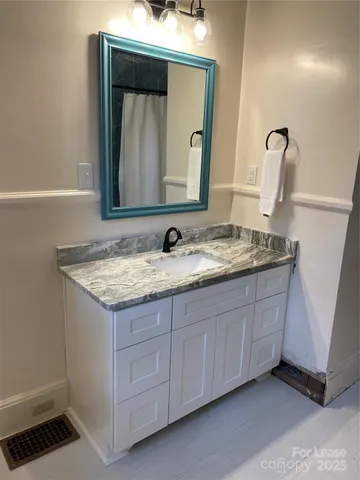 a bathroom with a granite countertop sink and a mirror