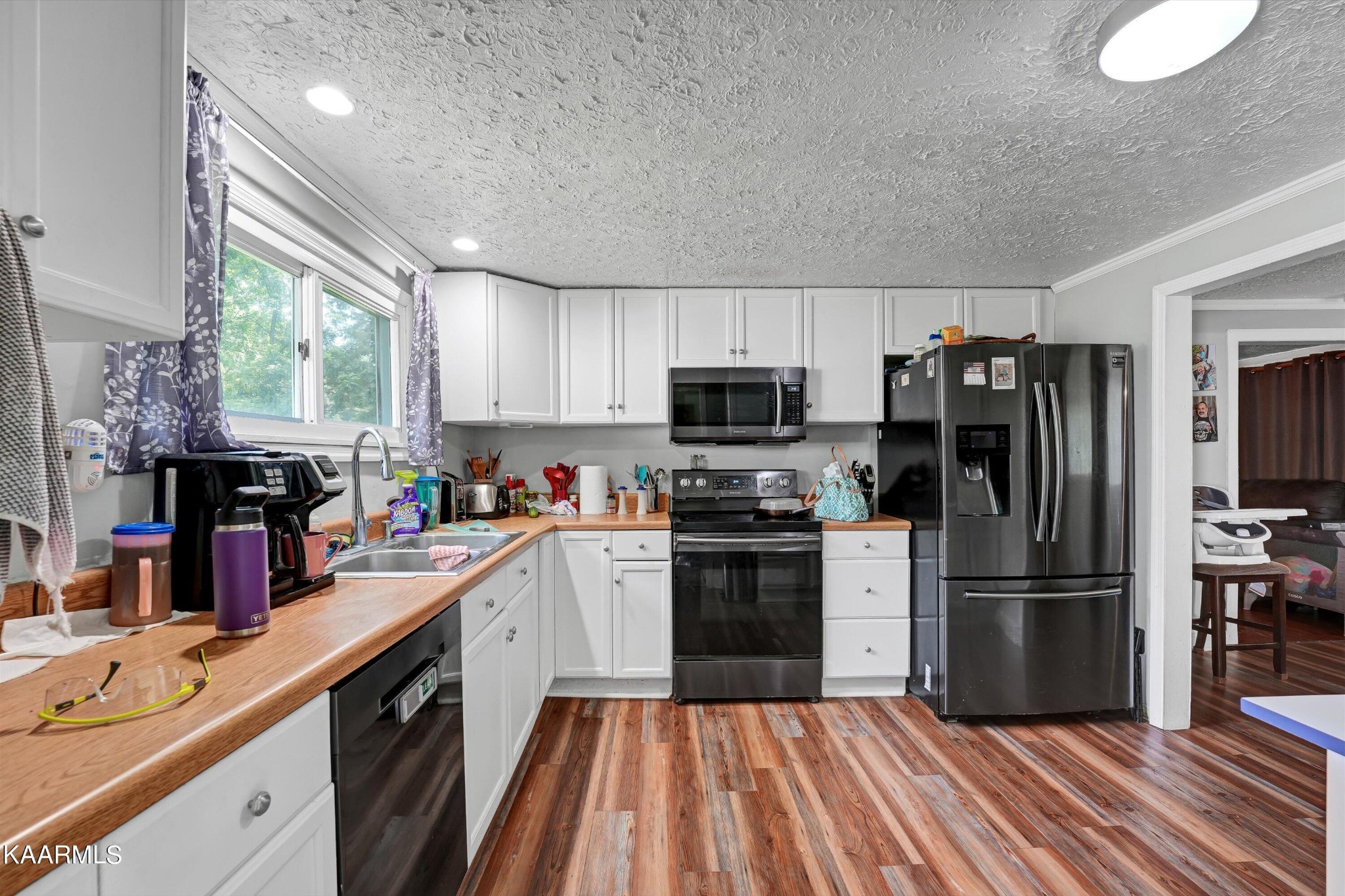 185 Moody Hollow Road Powell, TN 37849 - Photo 11 of 46 a kitchen with a refrigerator a stove top oven a sink dishwasher and wooden floor