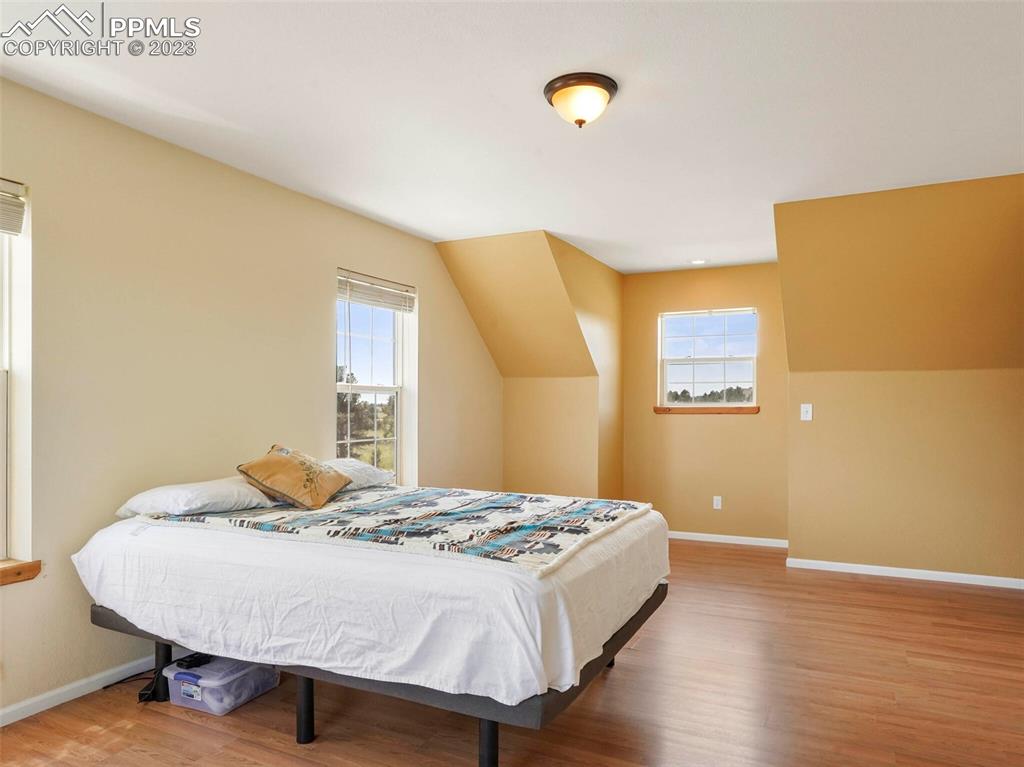 13550 Murphy Road Elbert, CO 80106 - Photo 23 of 42 a bedroom with a bed and wooden floor