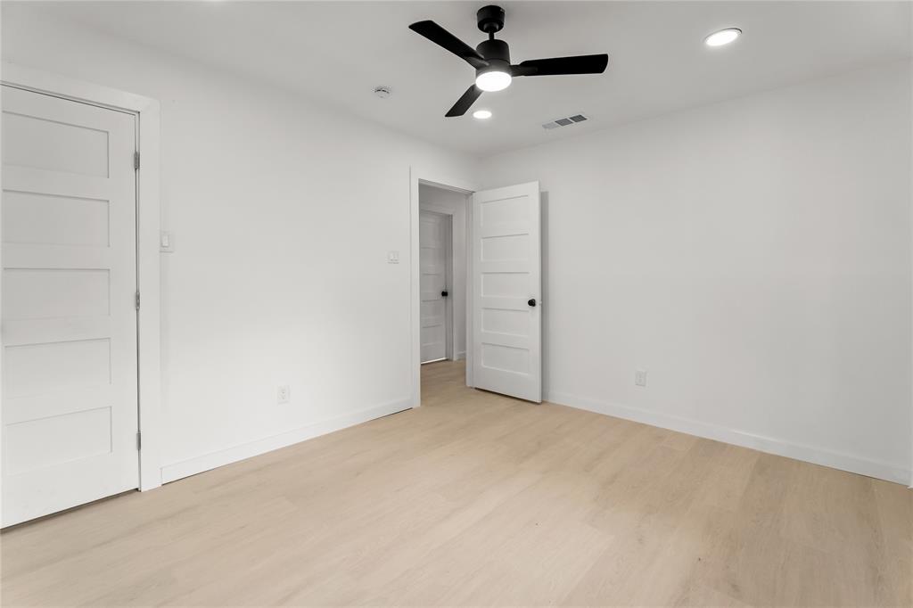 110 Hackberry Street Lancaster, TX 75146 - Photo 18 of 32 Bright interior space featuring light wood-finish flooring, white walls, and a black ceiling fan with integrated lighting