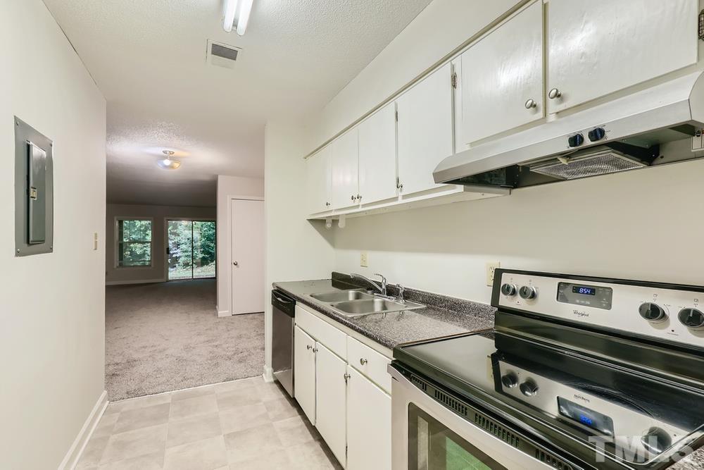 2518 Avent Ferry Road, Unit 103 Raleigh, NC 27606 - Photo 14 of 28 a kitchen with a stove and white cabinets