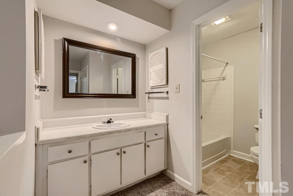 2518 Avent Ferry Road, Unit 103 Raleigh, NC 27606 - Photo 18 of 28 a bathroom with a toilet sink and mirror